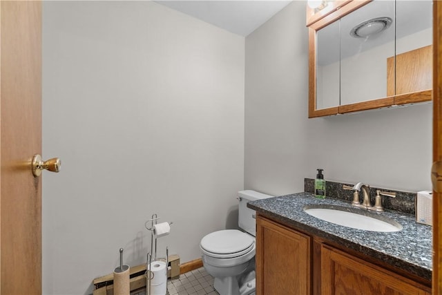 bathroom with toilet, vanity, and tile patterned floors