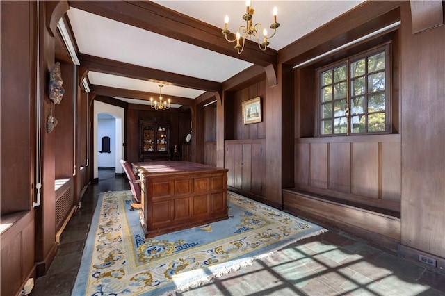 home office featuring beamed ceiling, wooden walls, and a chandelier