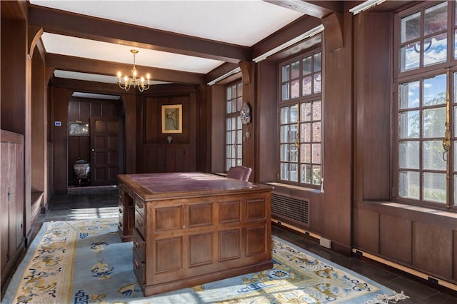 unfurnished office featuring beam ceiling, a chandelier, dark tile patterned flooring, and wood walls