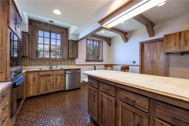 kitchen featuring sink, black oven, dishwasher, beam ceiling, and tasteful backsplash