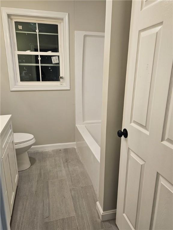 bathroom with hardwood / wood-style floors, toilet, and vanity