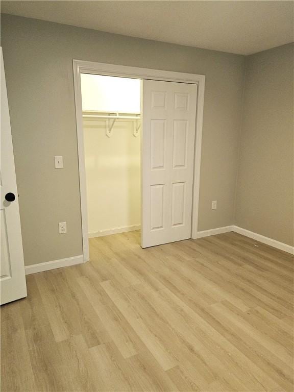 unfurnished bedroom with a closet and light hardwood / wood-style floors