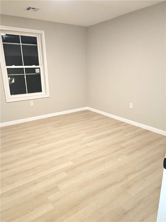 empty room with light hardwood / wood-style flooring