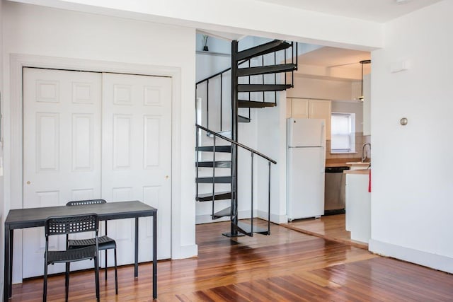 staircase with sink and wood-type flooring