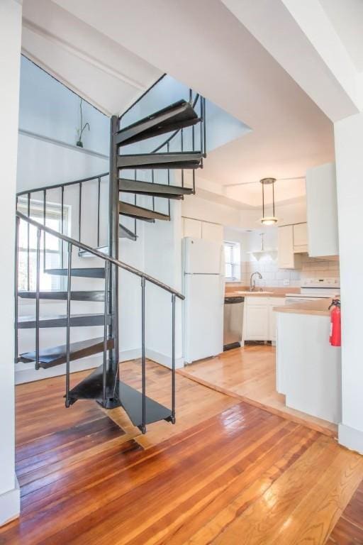 stairway with wood-type flooring and sink