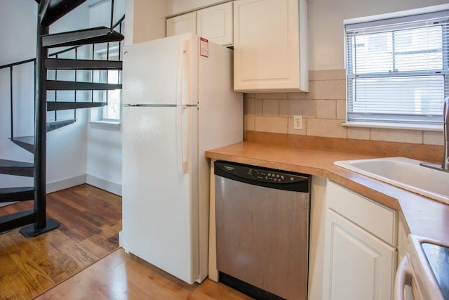 kitchen featuring white cabinetry, decorative backsplash, dishwasher, white refrigerator, and light hardwood / wood-style flooring