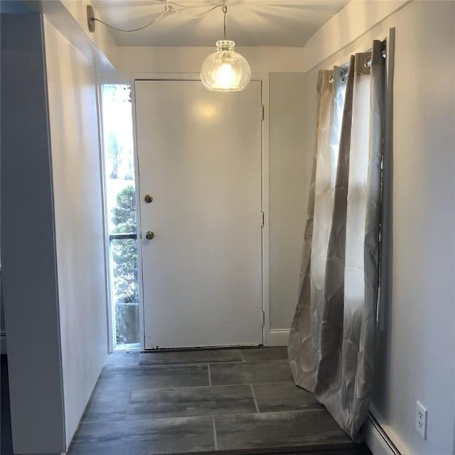 doorway to outside with dark wood-type flooring and a baseboard radiator