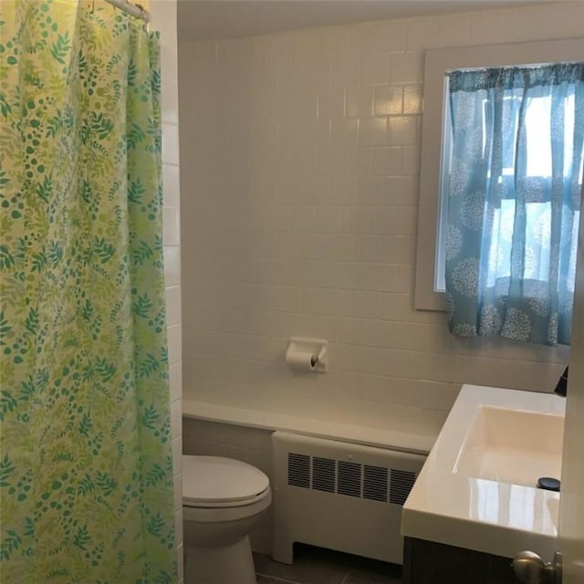 bathroom featuring tile patterned flooring, radiator heating unit, vanity, curtained shower, and toilet