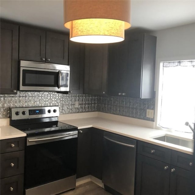 kitchen featuring sink, backsplash, hardwood / wood-style floors, and appliances with stainless steel finishes