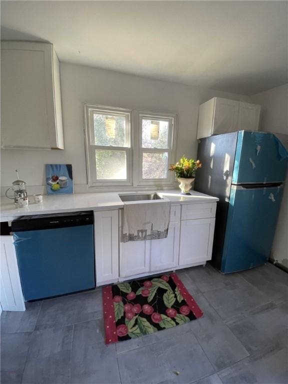 kitchen featuring fridge, dishwashing machine, and white cabinets