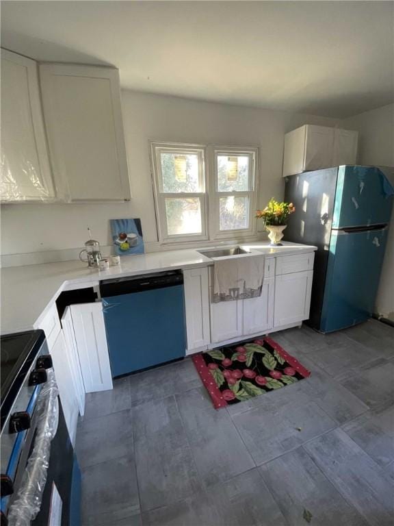 kitchen with electric range oven, white cabinetry, sink, stainless steel dishwasher, and black fridge