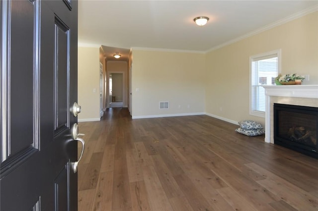 unfurnished living room featuring dark hardwood / wood-style flooring and crown molding