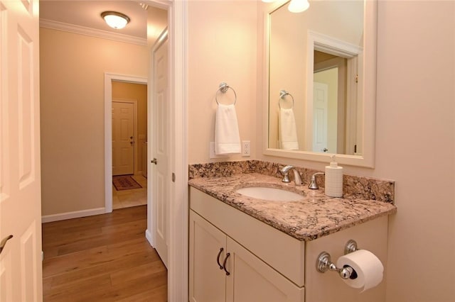 bathroom featuring vanity, crown molding, and hardwood / wood-style floors