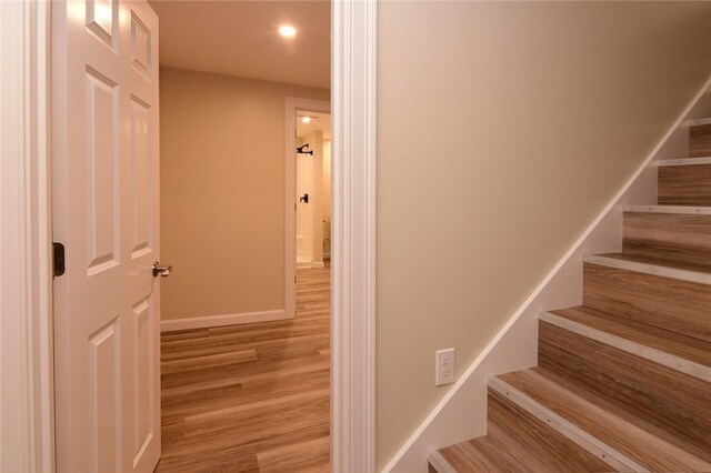 staircase with hardwood / wood-style floors