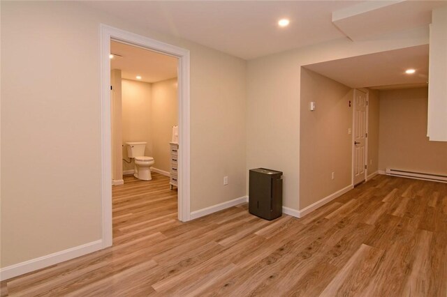 empty room with baseboard heating and light wood-type flooring