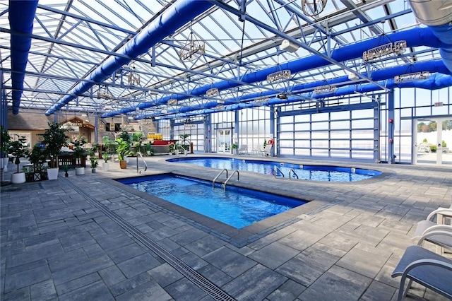 view of swimming pool featuring a patio area and an indoor in ground hot tub