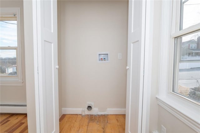 clothes washing area with light wood-type flooring, baseboard heating, and hookup for a washing machine