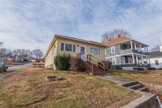 view of front of house with a balcony and a front yard