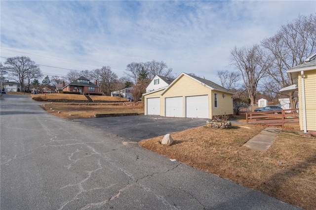 view of side of home featuring a garage and an outbuilding