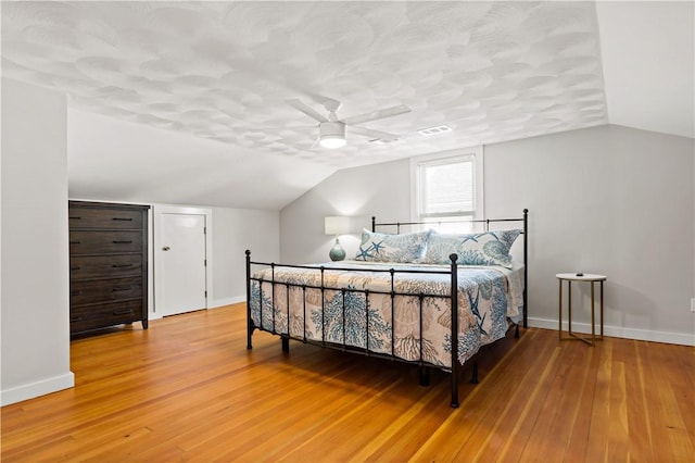 bedroom with hardwood / wood-style floors, vaulted ceiling, and ceiling fan