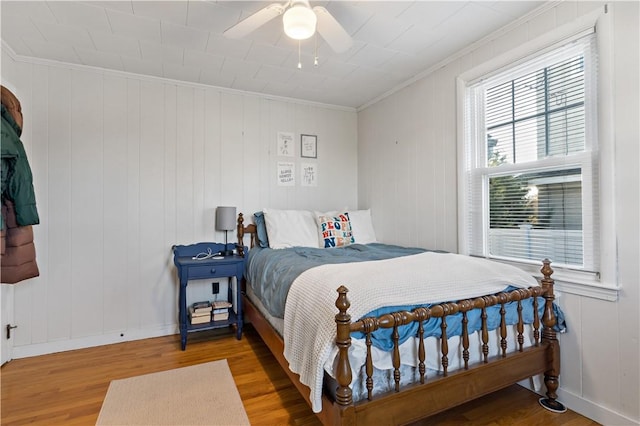 bedroom with ceiling fan, crown molding, and hardwood / wood-style floors