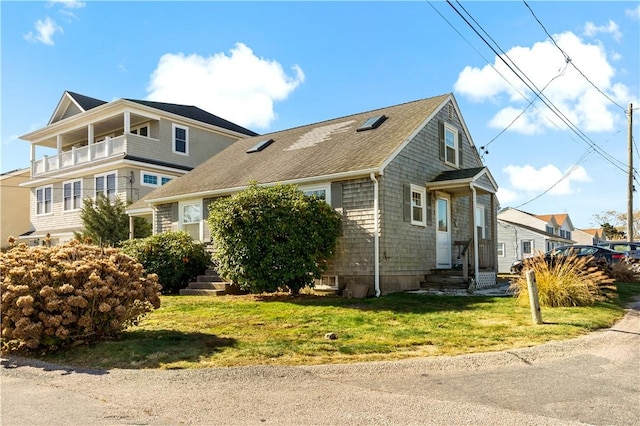 view of front of house with a front yard and a balcony