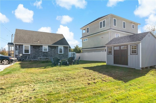 back of house featuring a storage shed and a yard