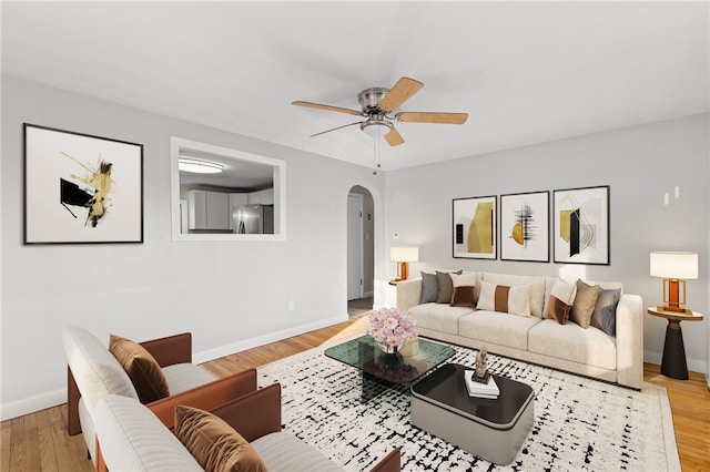 living room featuring ceiling fan and light hardwood / wood-style floors