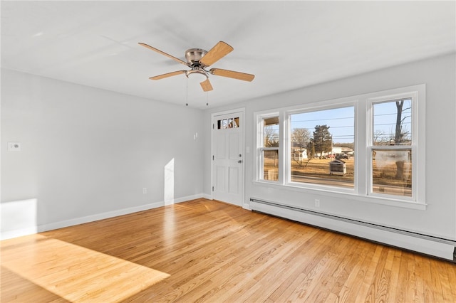 unfurnished room with ceiling fan, a baseboard heating unit, and light wood-type flooring