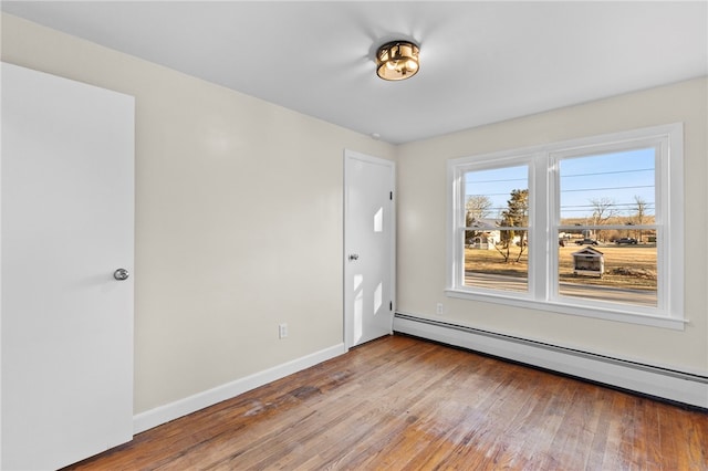 unfurnished room featuring a baseboard radiator and wood-type flooring