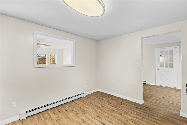 empty room with light hardwood / wood-style floors, a baseboard radiator, and ceiling fan