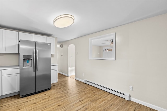 kitchen with light hardwood / wood-style floors, stainless steel refrigerator with ice dispenser, ceiling fan, a baseboard heating unit, and white cabinets