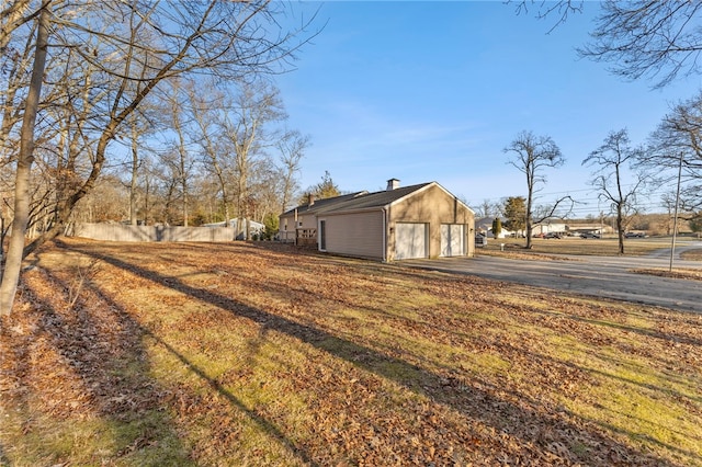 view of side of property with a garage and an outbuilding