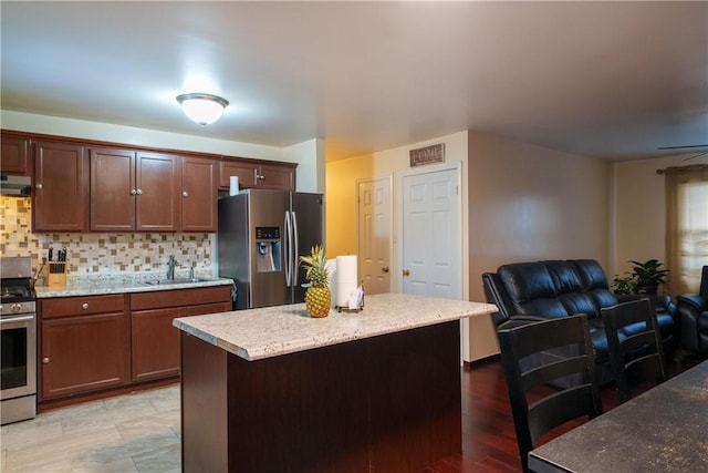 kitchen with a center island, exhaust hood, stainless steel appliances, sink, and backsplash