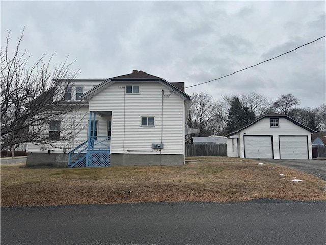 view of side of property with a garage, a yard, and an outdoor structure