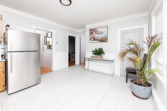 kitchen featuring stainless steel refrigerator and ornamental molding