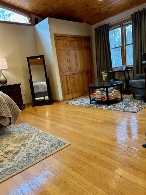 living area with wooden ceiling, vaulted ceiling, and light hardwood / wood-style flooring