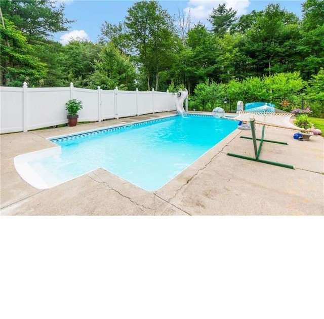 view of pool featuring a water slide and a patio