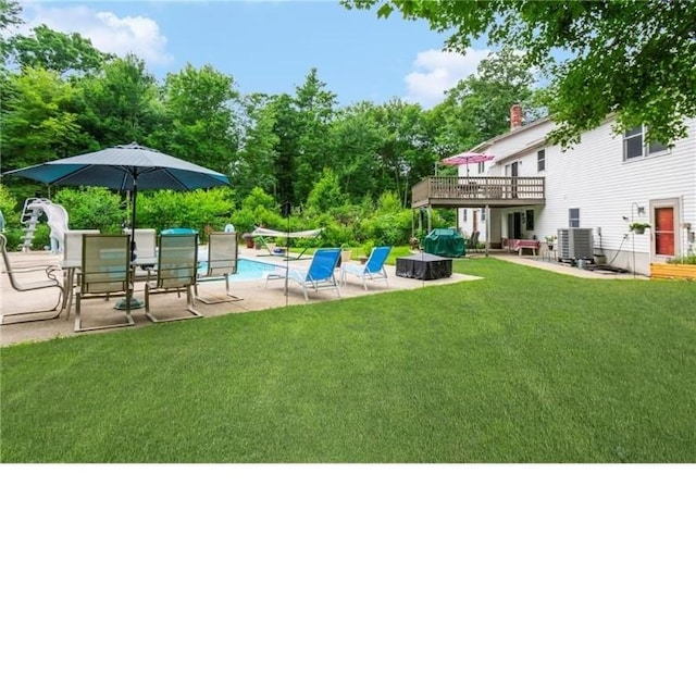 view of yard with a patio area, cooling unit, and a swimming pool side deck