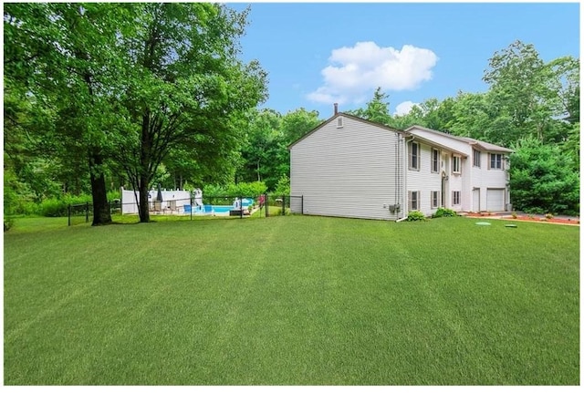 view of yard with a garage and a swimming pool