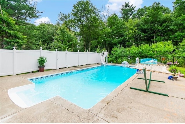 view of swimming pool with a patio and a water slide