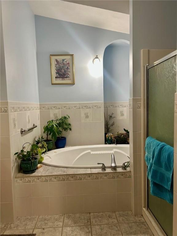 bathroom with tile patterned flooring and independent shower and bath