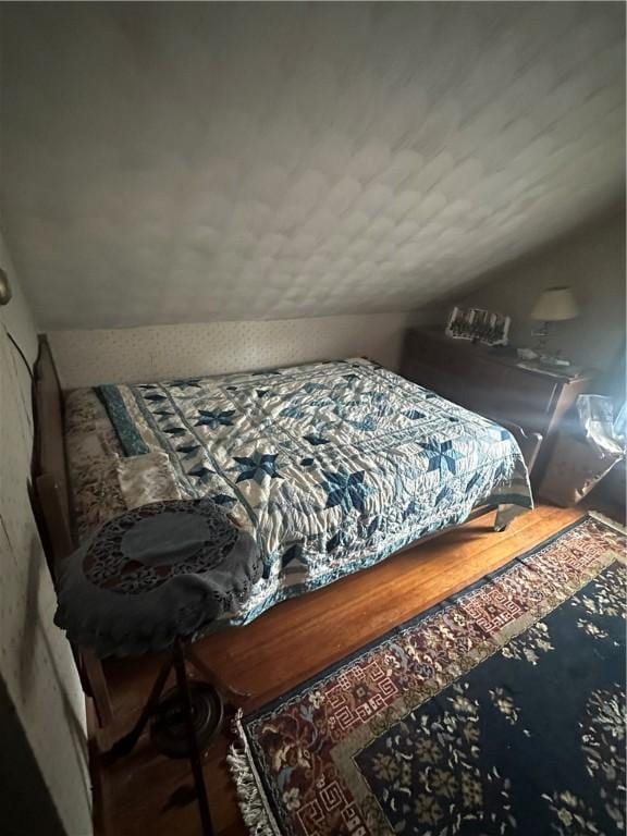 bedroom with lofted ceiling and a textured ceiling