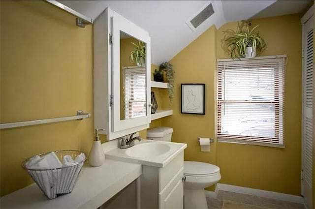 bathroom featuring vaulted ceiling, toilet, plenty of natural light, and vanity