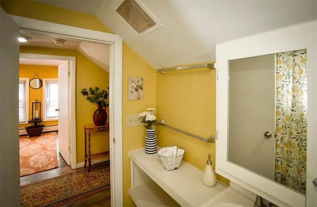 bathroom featuring vaulted ceiling and hardwood / wood-style flooring