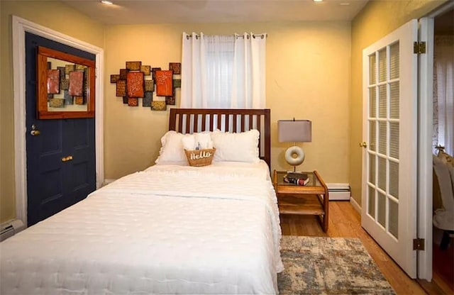 bedroom with wood-type flooring and a baseboard radiator