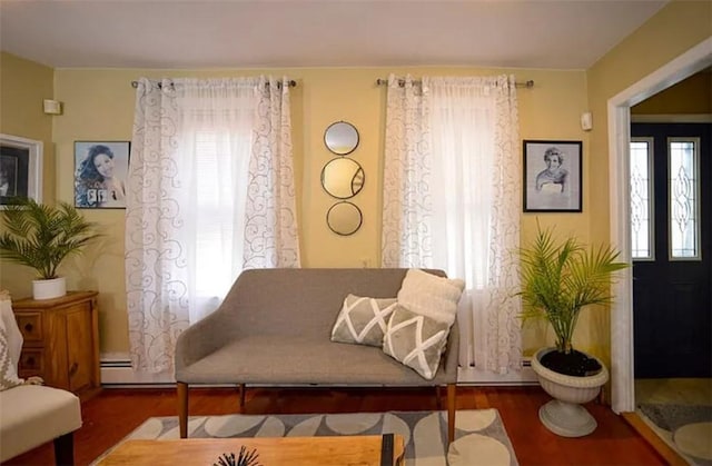 sitting room featuring a baseboard heating unit and dark hardwood / wood-style flooring