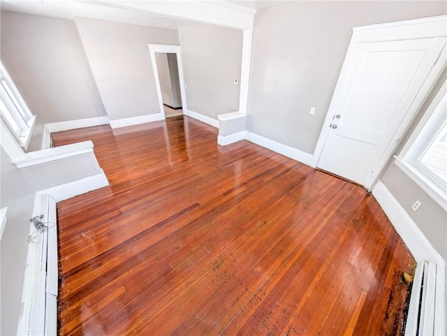 empty room with a baseboard heating unit and hardwood / wood-style floors