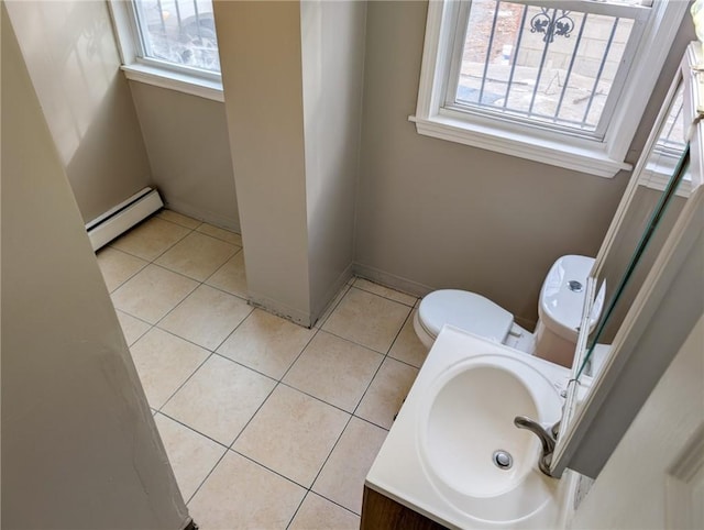 bathroom with tile patterned flooring, plenty of natural light, and a baseboard heating unit