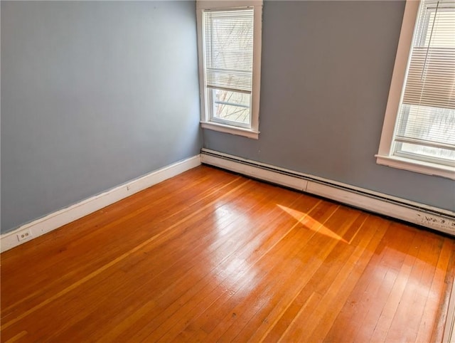 unfurnished room featuring light wood-type flooring and baseboard heating